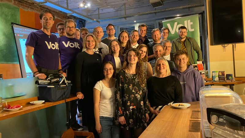Foto der Wahlparty von Volt Münster zur Kommunalwahl 2025 zeigt alle anwesenden Personen auf einem Gruppenbild. In Vorderster Reihe unsere neuen gewählten Ratspersonen